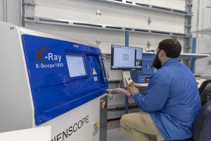 An employee at AGS Devices using the X-ray scope Scienscope 1800 machine for quality testing.