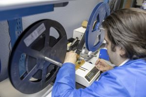 An employee performing receiving inspection on electronic components for quality control at AGS Devices.