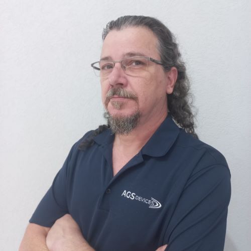 Jaeder Menossi, Senior Accounts Manager at AGS Devices, in a blue AGS Devices branded shirt.