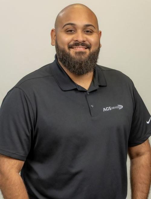 Jermaine Negroni, Operations Manager at AGS Devices, in a black AGS Devices t-shirt.